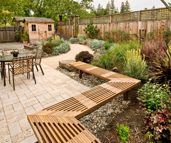 a beautifully area with Garden Landscaping and some tables, chairs and a cubby house in the background